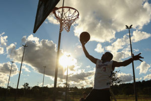 Homem jogando basquete ao ar livre 