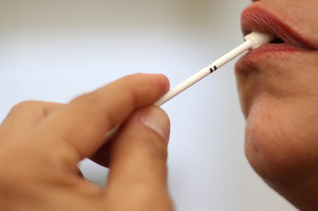 na foto, uma pessoa faz um teste rápido de hiv pela boca