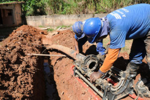 dois homens instalando um cano 