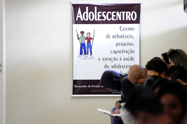 na foto, um cartaz escrito "adolescentro, centro de referência, pesquisa, capacitação e atenção à saúde do adolescente e família"