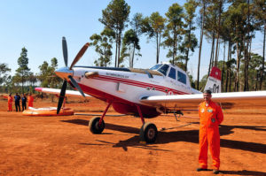 Pista de pouso com uma aeronave estacionada ao lado de um bombeiro