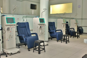 A imagem mostra cadeiras de hemodiálises em uma sala de hospital
