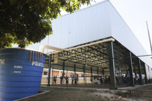 na imagem uma quadra de esportes cobertas e uma caixa d'água ligada a um sistema de captação de águas pluviais
