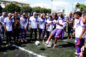 Morador chuta bola sob o olhar do governador Rollemberg no campo de grama sintética