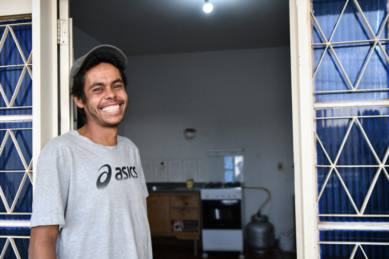 Foto com um homem sorrindo olhando para a câmera