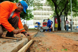 Homem martela calçada em construção