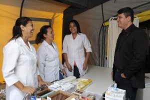 Profissionais da saúde de jaleco branco atendem paciente