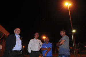 Homens em pé lado a lado sob poste de luz durante a noite